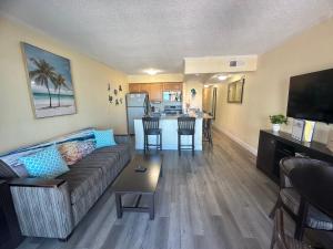 a living room with a couch and a table at Ohara Properties at Sailport Suites where your sunset views awaits!! in Tampa