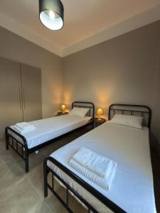 two twin beds in a room with two lamps at Plaza Vista in Kalamata +15 photos