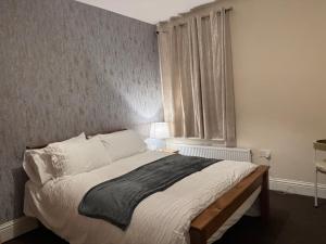 a bedroom with a bed and a window at LHChomeway in Earley
