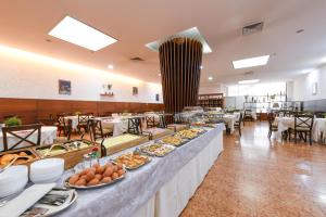 a buffet line with plates of food in a restaurant at Hotel Garda in Affi