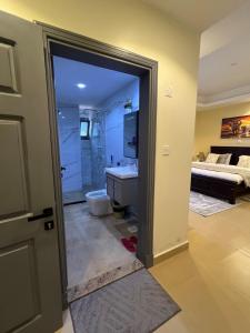 Un baño con lavabo, inodoro y una cama. en Reeq Residence Naguru Kampala, en Nalakonge