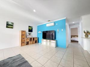 a living room with a blue wall and a tv at City Explorer Base 3BR&2 Floors&Walk to Mall & Airport Transit in Perth