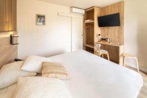 a bedroom with a white bed and a desk at Sure Hotel by Best Western Mont-de-Marsan in Saint-Pierre-du-Mont