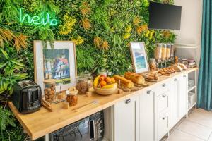 a table with bread and fruit on it in front of a green wall at Sure Hotel by Best Western Mont-de-Marsan in Saint-Pierre-du-Mont