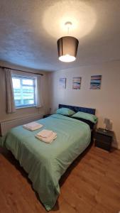 a bedroom with a large green bed with a light at 1-Bedroom Annexe in Brighton-Saltdean in Saltdean