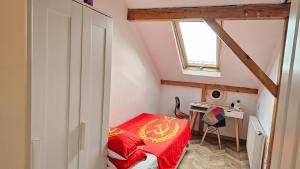 a small bedroom with a red bed and a desk at Private room at Ceausescu's place in Old City Unirii Square in Bucharest