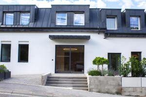 a white house with a black roof at Hotel Taxis Bratislava in Bratislava