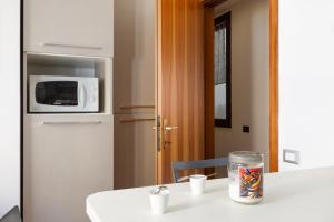 cocina con mesa, microondas y nevera en Vecellio, rustico in centro a Trieste, en Trieste 23 fotos más