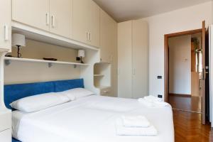Un dormitorio con una cama blanca con dos toallas encima. en Vecellio, rustico in centro a Trieste, en Trieste