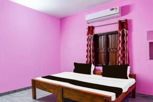 a bed in a room with a pink wall at Hotel O Sai Homes in Kātni