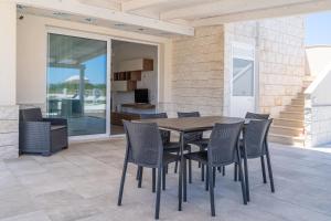 einen Esstisch und Stühle auf einer Terrasse in der Unterkunft Villa very close to Santa Maria Del Focallo beach blue flag with private pool in Santa Maria Del Focallo