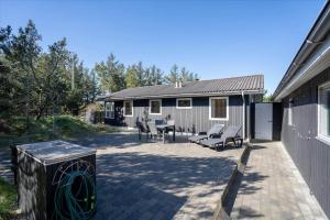 un patio avec des chaises et une table et un bâtiment dans l'établissement 233-Ringkobing-Milevej-38, à Klegod