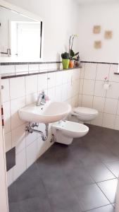 a white bathroom with a sink and a toilet at Lichtdurchflutete grosse Wohnung in Isny im Allgäu