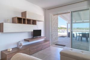 ein Wohnzimmer mit Fernseher und Sofa in der Unterkunft Villa very close to Santa Maria Del Focallo beach blue flag with private pool in Santa Maria Del Focallo