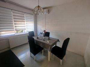 a dining room with a table and black chairs at Novi dom in Gornji Milanovac +9 photos