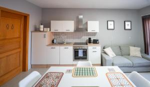 a kitchen and living room with a table and a couch at The Bayview Executive Penthouse in Marsaskala