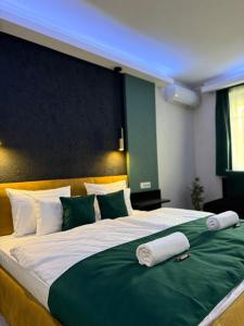a large bed with green and white sheets and pillows at Casa Lara Apartman in Egerszalók