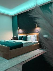 a bedroom with a large bed with green sheets and pillows at Casa Lara Apartman in Egerszalók