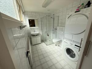 a bathroom with a washing machine and a sink at Theislandlife 10p Centrum Texel in Den Burg +20 photos