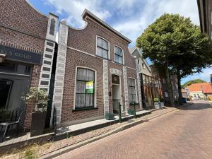 a brick building on the side of a street at Theislandlife 10p Centrum Texel in Den Burg