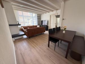 a living room with a table and a couch at Theislandlife 10p Centrum Texel in Den Burg