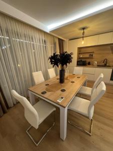 a dining room with a table and white chairs at AmyMamaia marina blue in Mamaia
