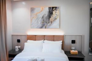 a bed in a hotel room with a picture above it at Kabin Tiny Home in Roxas City +38 photos