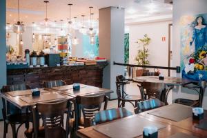 a restaurant with tables and chairs and a bar at The Hotel in Salvador
