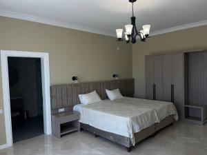a bedroom with a large bed and a chandelier at Гостевой дом Добрые Традиции Good Traditions Guest House in Itʼkhvisi +7 photos