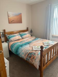 a bedroom with a large bed with a wooden frame at Coastal Comforts in Newcastle