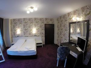 una habitación de hotel con una cama y un espejo en VIP Apartments Dobrevi, en Primorsko