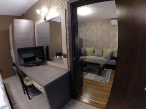 Habitación con escritorio, espejo y sofá. en VIP Apartments Dobrevi, en Primorsko