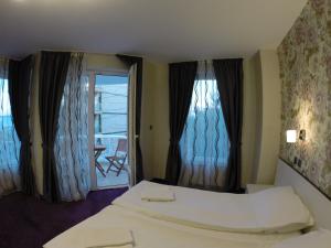una habitación de hotel con una cama y un balcón en VIP Apartments Dobrevi, en Primorsko