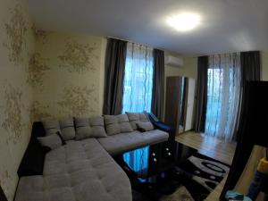 Una sala de estar con un sofá y algunas ventanas. en VIP Apartments Dobrevi, en Primorsko 6 fotos más