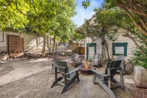 un patio trasero con sillas y una hoguera en The Cottage House, en Ouray