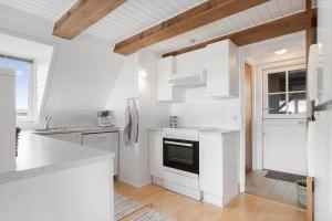 eine weiße Küche mit Herd und Spüle in der Unterkunft 260 Ringkøbing - Vestklitvej 13 in Klegod