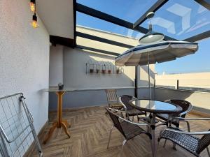 a balcony with a table and chairs and an umbrella at Apto aconchegante e familiar em BC in Balneário Camboriú