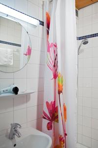 ein Badezimmer mit einem Waschbecken und einem Duschvorhang mit Blumen in der Unterkunft Hotel Erbprinzenhof in Karlsruhe