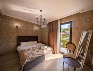 a bedroom with a bed and a window and chairs at Sunny Days Borjomi in Borjomi