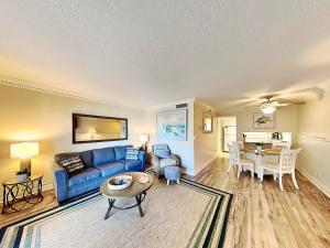 a living room with a blue couch and a table at Bent Palm 218 in Ormond Beach
