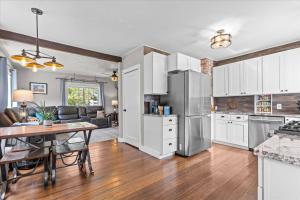 a kitchen with white cabinets and a table with a dining room at Blue Door Breeze in Coeur d'Alene