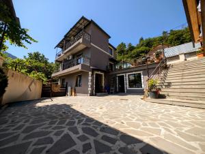 a house with a stone courtyard in front of it at Sunny Days Borjomi in Borjomi