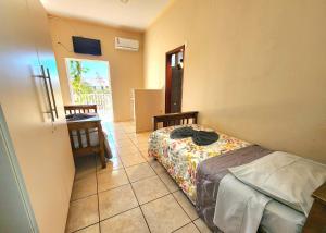 a bedroom with a bed and a tiled floor at Économique Hotel in Ilha Solteira +3 photos