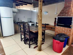 a kitchen with a table and chairs in a kitchen at Économique Hotel in Ilha Solteira