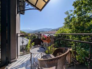 a balcony with a table and chairs and a view at Sunny Days Borjomi in Borjomi