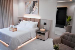 a bedroom with a bed and a chair and a television at Kabin Tiny Home in Roxas City