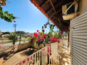 a balcony with pink flowers on a building at Économique Hotel in Ilha Solteira