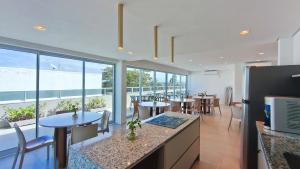 a restaurant with tables and chairs and windows at Mila Rooftop - Praia de Tamandaré in Tamandaré