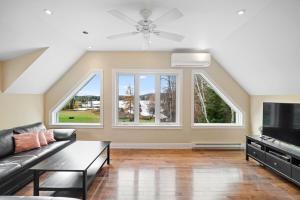 Saint-CalixteMagnificent Riverside Bright Chalet with Spa的客厅里有一张沙发和一台电视