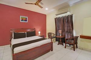 una camera da letto con un letto e una parete rossa di Hotel O Ruma Near Nampally Railway Station a Hyderabad